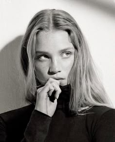 a black and white photo of a woman with long blonde hair wearing a turtle neck sweater