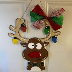 a door hanger with a reindeer head and christmas lights hanging from it's side