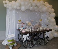 a table topped with lots of white balloons