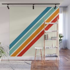 a wall mural with multicolored stripes on it in a living room next to a book shelf