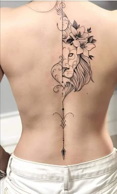 a woman's back with a lion and arrow tattoo on her left side ribcage