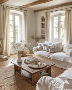 a living room filled with lots of white furniture