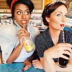 two women sitting at a table with drinks