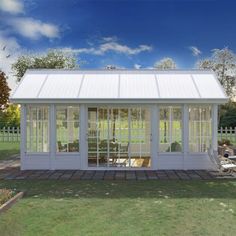 a small white house sitting on top of a lush green field