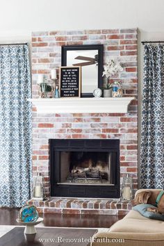 a living room with a brick fireplace and blue curtains