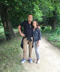 a man and woman standing on a dirt path