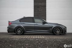 a grey car parked in front of a garage door