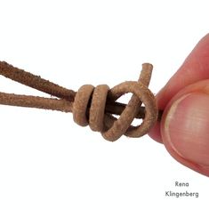 a hand holding a piece of rope that is knoted together