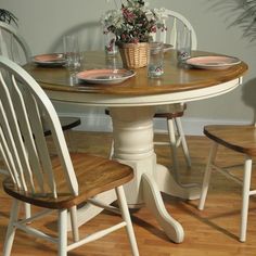 a table with two chairs around it and a potted plant on the table top