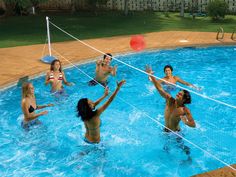 a group of people playing volleyball in a pool