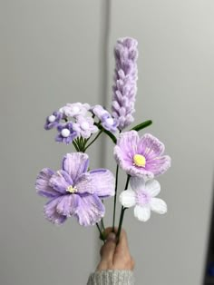 a person is holding some flowers in their hand