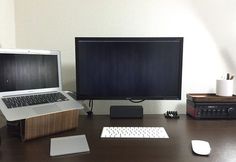 a laptop computer sitting on top of a wooden desk next to a monitor and keyboard