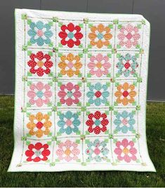 a quilt made with flowers on the grass