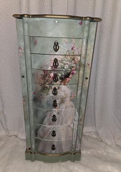 a painted cabinet with drawers and knobs on the bottom, in front of a white background