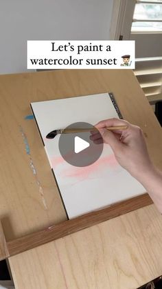 someone is painting a watercolor sunset on a piece of wood