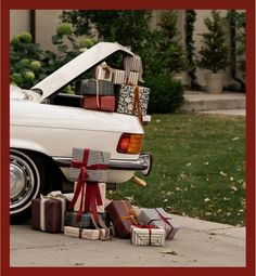 a white car with its hood open and presents under it