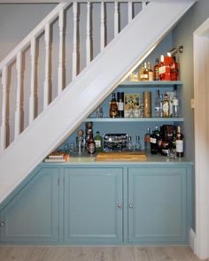 an under the stairs bar with liquor bottles on it