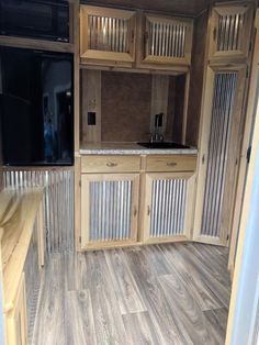 the inside of an rv with wood flooring and cabinets