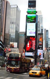 a busy city street filled with lots of traffic and tall buildings covered in billboards