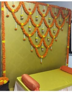 an orange and yellow decoration is hanging on the wall next to a green table cloth