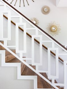 a white staircase with wooden handrails and wood flooring