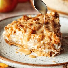 a spoon drizzling caramel sauce onto a piece of apple pie on a plate