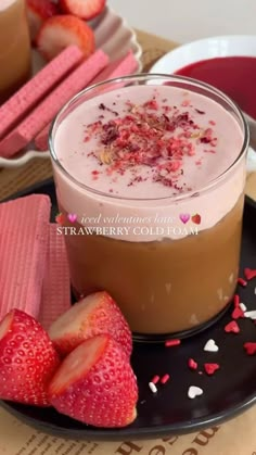 two desserts on a plate with strawberries in the middle and pink hearts scattered around them