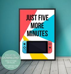 a poster that says just five more minutes next to a nintendo game controller on a wooden floor