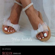 a woman's feet wearing sandals with bows and pearls