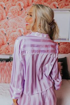 - Make time to unwind with luxe style in this cozy pajama top! - Lightweight, unlined material with a vertically striped pattern and a satin finish - A collared neckline - A functional chest pocket - Long, loose sleeves with cuffs - A button up front - A relaxed silhouette that ends in a straight hemline with accent side slits Spring Satin Loungewear Top, Long Sleeve Tops With Striped Collar For Loungewear, Purple Spring Sleepwear For Home, Spring Purple Home Sleepwear, Purple Sleep Tops For Spring, Spring Purple Sleep Top, Purple Spring Sleep Top, Luxe Style, Cozy Pajamas