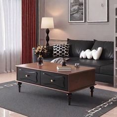 a living room with black leather couches and red curtains on the window sill