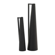 two tall black vases sitting next to each other on top of a white surface