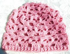 a pink crocheted hat sitting on top of a table