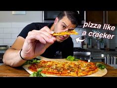 a man is about to take a bite out of a pizza that has been placed on a cutting board