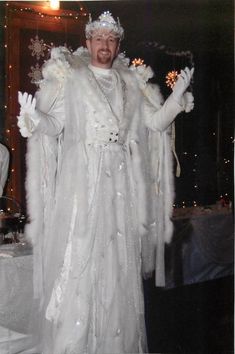 a man dressed in white standing next to a table