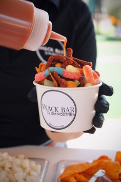 a person holding a cup filled with cereal