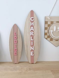 three wooden surfboards are hanging on the wall in front of a clock and other decorations