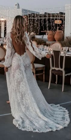 the back of a woman's wedding dress, with long sleeves and open shoulders