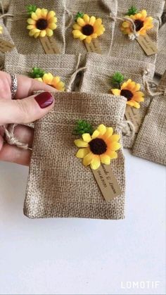 a hand holding a small bag with sunflowers on it