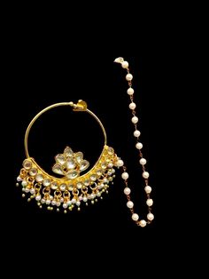 a pair of gold hoop earrings with pearls