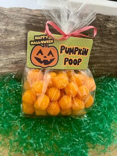 a plastic bag filled with pumpkin poop sitting on top of green grass