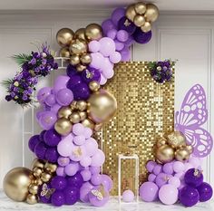 a purple and gold balloon arch with balloons