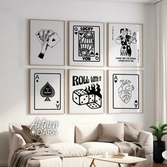 a living room filled with white furniture and pictures on the wall above it's coffee table