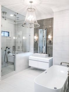 a white bathroom with a tub, sink and shower stall in it's corner