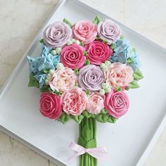 a bouquet of pink and blue flowers on a white tray