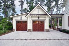 a white house with two brown garage doors