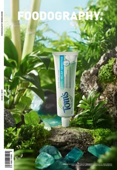 a tube of toothpaste sitting on top of a rock next to some plants