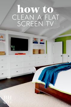 a bedroom with green walls and white furniture, including a large tv mounted on the wall