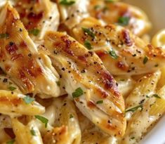 pasta with chicken and parsley in a white bowl