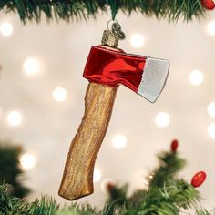 an ornament hanging from a christmas tree with lights in the background and a hammer on it